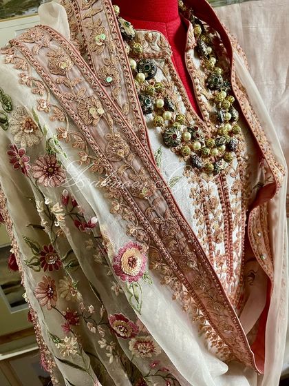 A mannequin shot of the suit, styled with a necklace to show its festive readiness.