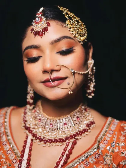 A close-up with eyes closed, this shot provides a detailed view of the peachy-golden glittery eye makeup. The blend is seamless, creating a beautiful, multi-dimensional effect.