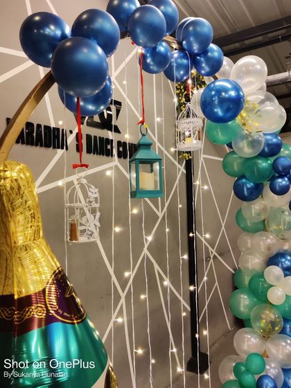 A detailed shot of our creative balloon arrangements. Here, we used metallic blue balloons and hanging birdcage props to add a unique touch to a birthday party setup.