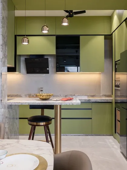 The breakfast bar, with its marble top and brass-finished support, serves as a beautiful transition between the kitchen and the living space. It’s perfect for quick meals or a morning cup of coffee.