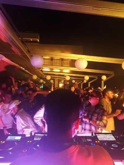 A view from my console of the packed dance floor during a sundowner. The paper lanterns and open-air setting add to the unique vibe.