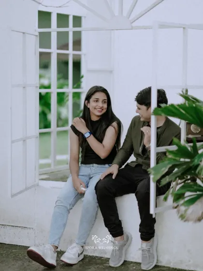A candid moment of conversation and laughter as the couple sits together in a charming white window.