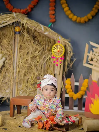 A classic portrait from the Lohri theme, with the baby looking sweetly at the camera in a festive and warm setting.