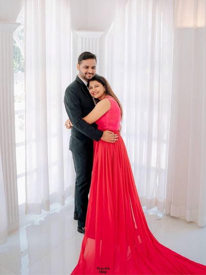 A joyful embrace in a bright, airy room. This pre-wedding photo captures the couple's happiness and the elegant simplicity of their surroundings.