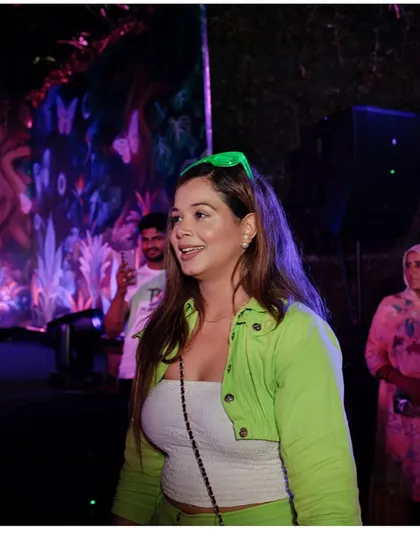 A smile on my face as I watch the crowd enjoy the neon party I'm hosting.