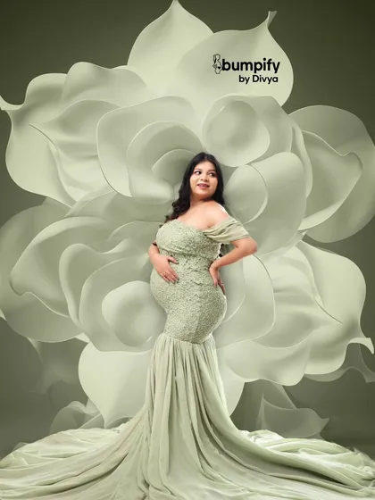 A powerful and artistic pose with the mom-to-be in a form-fitting green lace gown against a giant white flower backdrop. This shot beautifully highlights the curves of pregnancy.