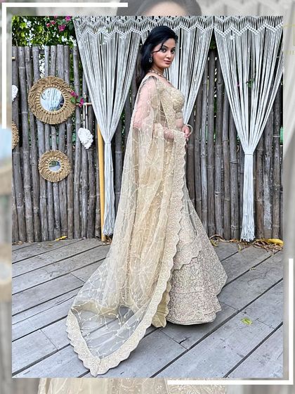 A side view of the beige lehenga, highlighting the delicate net dupatta with its scalloped border.