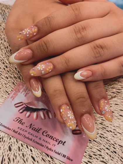 A cheerful and delicate design perfect for spring. This set features a pale yellow French tip with accent nails covered in hand-painted white daisies with crystal centers.