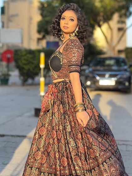 A full-length shot of the Ajrakh lehenga, showing the beautiful flare of the skirt and the potli bag accessory. This is how you make an entrance.