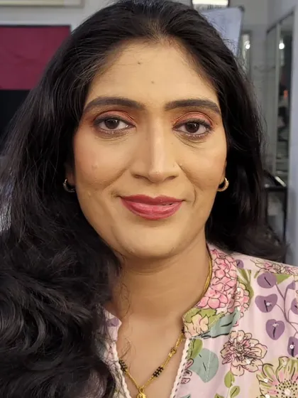 This is a corrective makeup application designed to even out skin tone and enhance natural features. The final look is fresh and bright, with soft pink tones on the eyes and lips, suitable for a daytime event.