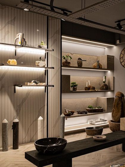 A wide shot of the product display area, showing how different shelving styles and lighting techniques are used to create visual rhythm. The combination of floating shelves and recessed, lit niches allows each product group to have its own moment.