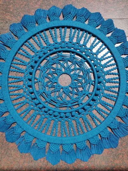 A beautiful macrame mandala in a striking shade of teal blue. This piece is perfect as a standalone wall hanging to add a pop of color and intricate texture.