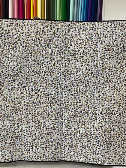 The back of the Disney quilt, featuring a fabric printed with letters.