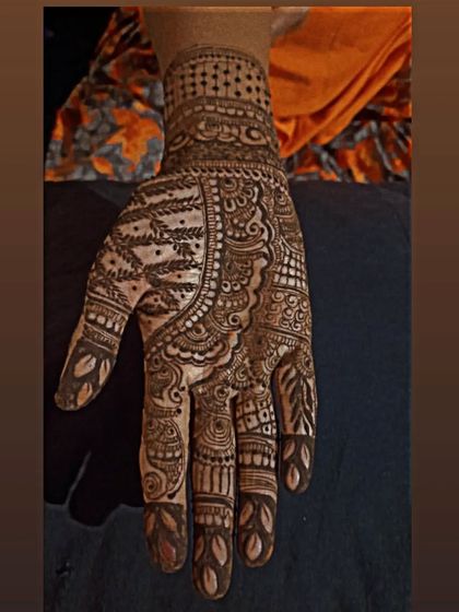 This is a classic, dense Indian bridal design. The entire palm is filled with detailed patterns, including fine lines, dots, and traditional motifs, perfect for the bride who wants maximum coverage.