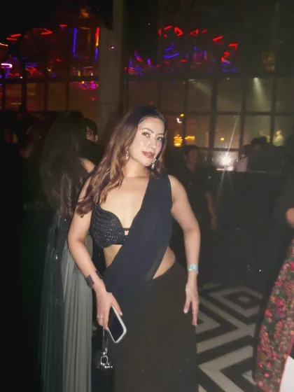 A modern black saree with a sequined bralette, styled for a club night or a glamorous party.