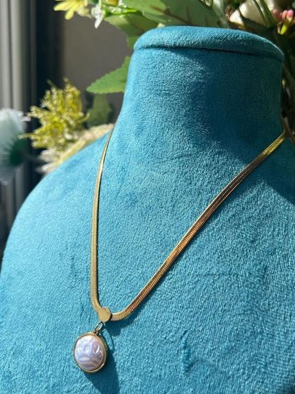 A delicate snake chain necklace with a pearl-like pendant from Medusa House of Jewel.