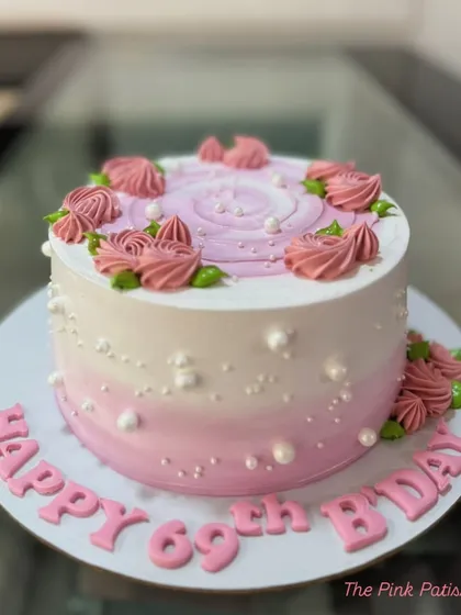 A pretty pink ombre cake for a 69th birthday, decorated with piped roses and delicate pearls.