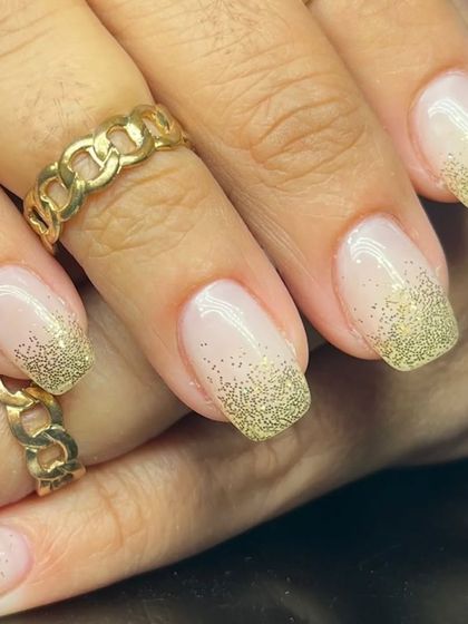 A closer look at the gold glitter fade French manicure, perfect for a festive or celebratory occasion.