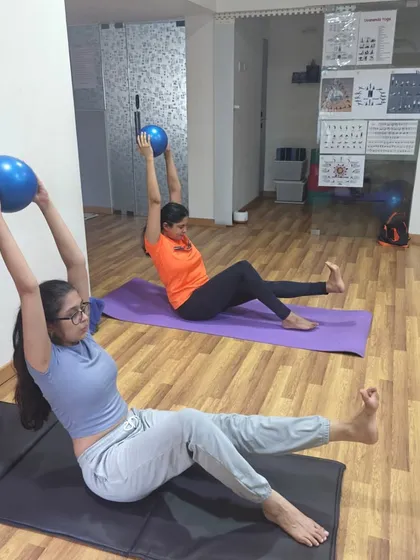 Building core strength with a stability ball. This exercise, a variation of Navasana (Boat Pose), challenges balance and deeply engages the abdominal muscles.