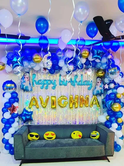 A magical "Frozen" themed birthday party. This decoration uses a blue, white, and silver color scheme to create a winter wonderland, complete with a balloon garland, shimmer backdrop, and foil balloons of Elsa.