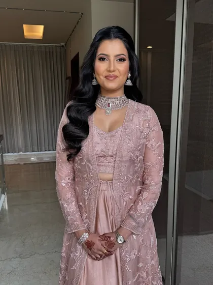 A classic half-pinup style with voluminous waves cascading down one shoulder. This is a timeless party hairstyle that suits many face shapes and outfits.