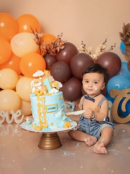 A little taste of birthday cake. This one-year-old is enjoying his special treat in our boho-themed setup with a beautiful balloon arrangement.