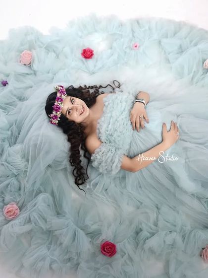 A dreamy overhead shot shows the mother-to-be as the center of her own beautiful universe, encircled by her flowing gown and scattered roses.