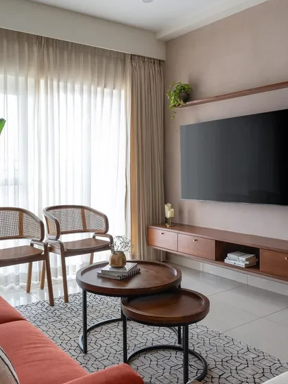 The TV wall in the 'Living life in Colour' project features a floating teak console against a soft peach textured wall, creating a warm and inviting focal point.