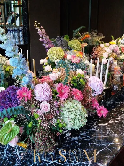 This riotous yet romantic arrangement was designed for a host who wanted to express radiating love. The mix of pastels, brights, and candles on a black marble table creates a stunning pop of luxury for any event.