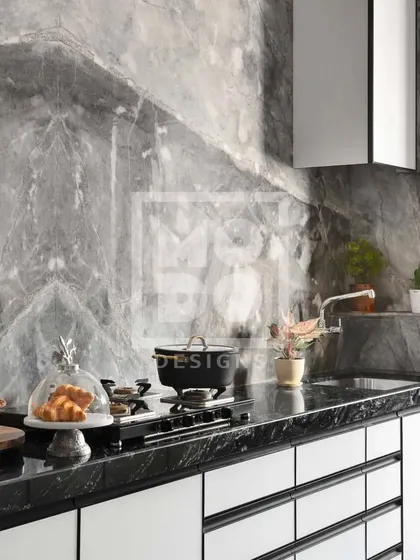Another angle of this sleek kitchen, highlighting the dramatic grey marble wall. The minimalist white cabinets and black countertop create a bold contrast, making the space feel both modern and timeless.