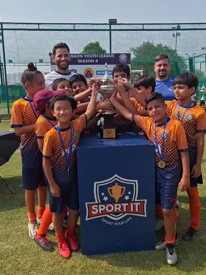Together, they lift the trophy. A powerful image of teamwork and shared success at the GYL finals.