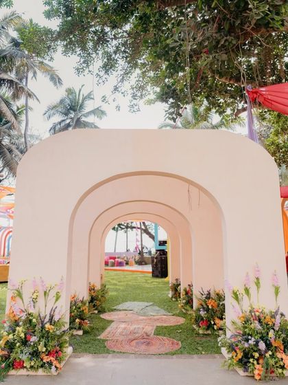 A beautiful arched walkway leading into the main event area. The clean, modern arches are lined with flowers, creating an elegant and inviting entrance.