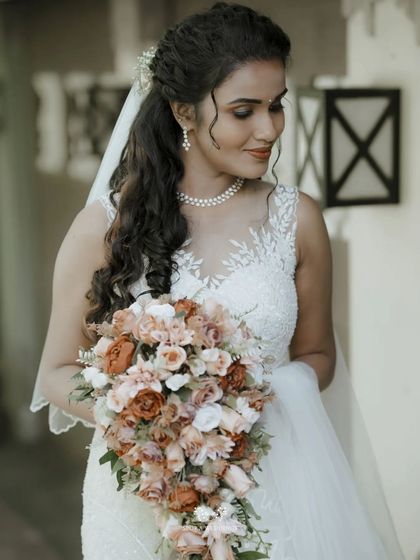 The bride looking radiant as she holds her cascading bouquet, her elegant dress and makeup perfectly captured.