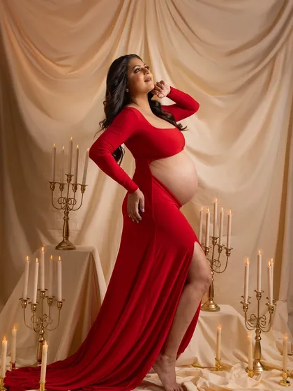 A dramatic and romantic solo portrait in a bold red gown, surrounded by the warm glow of candlelight.