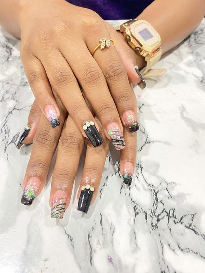 This dark and edgy design showcases a student's versatility. It combines black nails with negative space, fine-line art, and carefully placed crystal accents for a sophisticated, modern look.