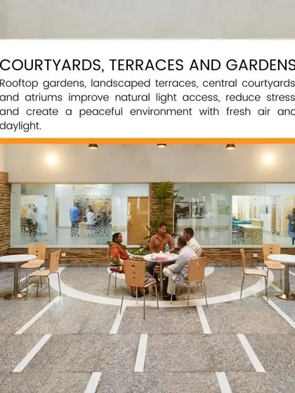 Rooftop gardens, landscaped terraces, and central courtyards improve natural light access and create a peaceful environment. This outdoor seating area provides a space for fresh air and stress reduction.