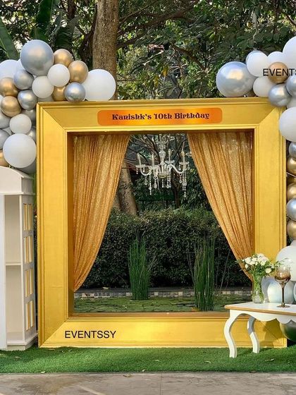 A fun and elegant photo booth designed as a giant golden frame, complete with drapes and a chandelier. It provided a perfect spot for guests to take pictures at the royal-themed 10th birthday party.