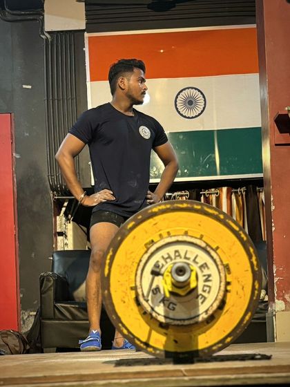 One of my athletes standing proud in front of the Indian flag. We lift for ourselves, for our team, and for our country.
