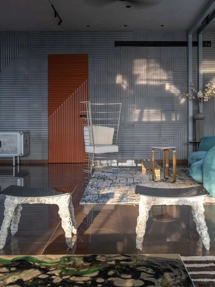 The interior is a playground of textures and forms, with corrugated walls, sculptural furniture, and a bold use of color.