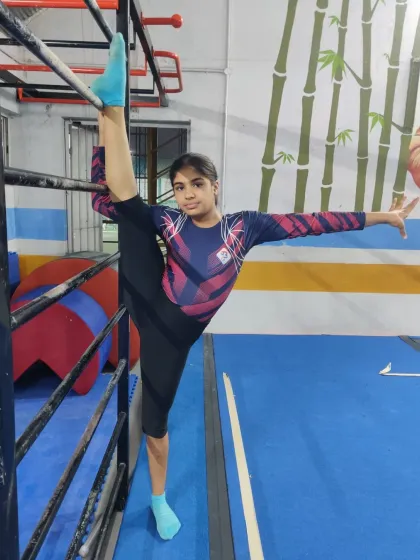 With a look of pure determination, this gymnast holds a standing split. We encourage our students to push their boundaries while maintaining proper form.