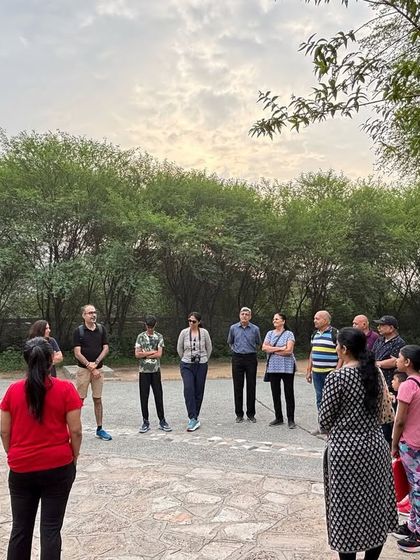 A community group gathers in a circle at sunrise in the Badshahpur Forest Corridor, ready to begin their guided nature walk.