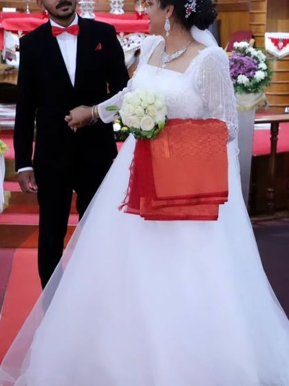 A precious moment from Jittu's wedding ceremony. The gown, with its elegant square neckline and detailed beadwork, looks perfect in the traditional church setting.
