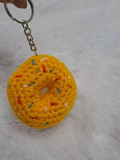 A fun and colorful donut keychain with sprinkles. It's a sweet little accessory for your keys or backpack.
