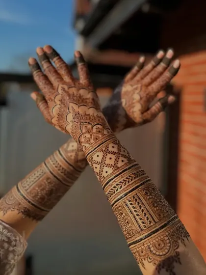 A beautiful shot of a full bridal design in the golden hour light, showing the rich texture of the henna.