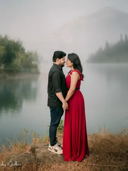 A breathtaking portrait with the misty mountains reflected in the still lake. Nutan and Shubham stand together, a moment of quiet connection in a vast, beautiful landscape.
