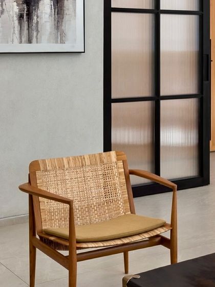 A detail of a woven-back chair in the Mango Orchard House. We often incorporate handcrafted elements and natural textures to add warmth and character to our minimalist designs.