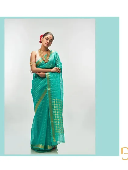 A full-length portrait in the light sea green saree, a picture of calm and sophisticated elegance.