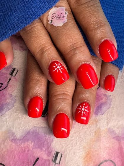 Simple and sweet Christmas nails. A classic bright red polish with a delicate white snowflake on the accent nails.