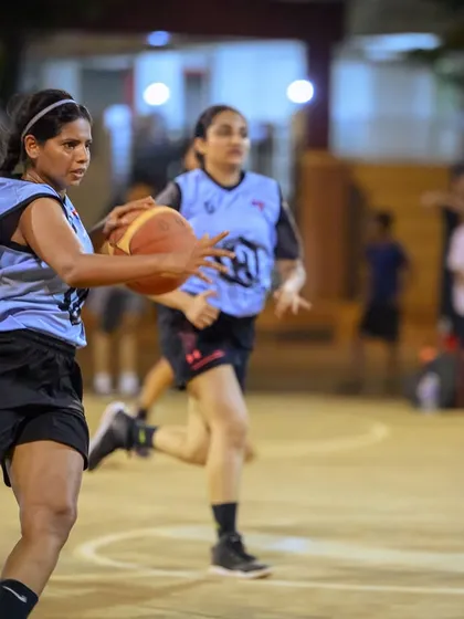 A women's player on a fast break, pushing the ball up the court with speed and control.