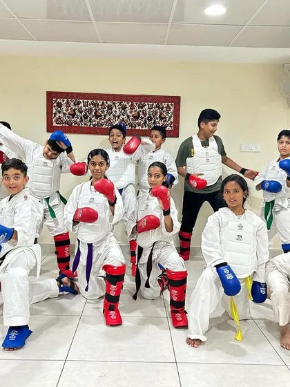 Ready for the challenge. A group of our students geared up in full WKF-approved protective equipment for a kumite (sparring) practice session, ready to train with intensity.